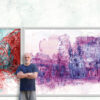 Vladimir Radibratovic poses in front of a piece of art from his "Cityscapes" series.